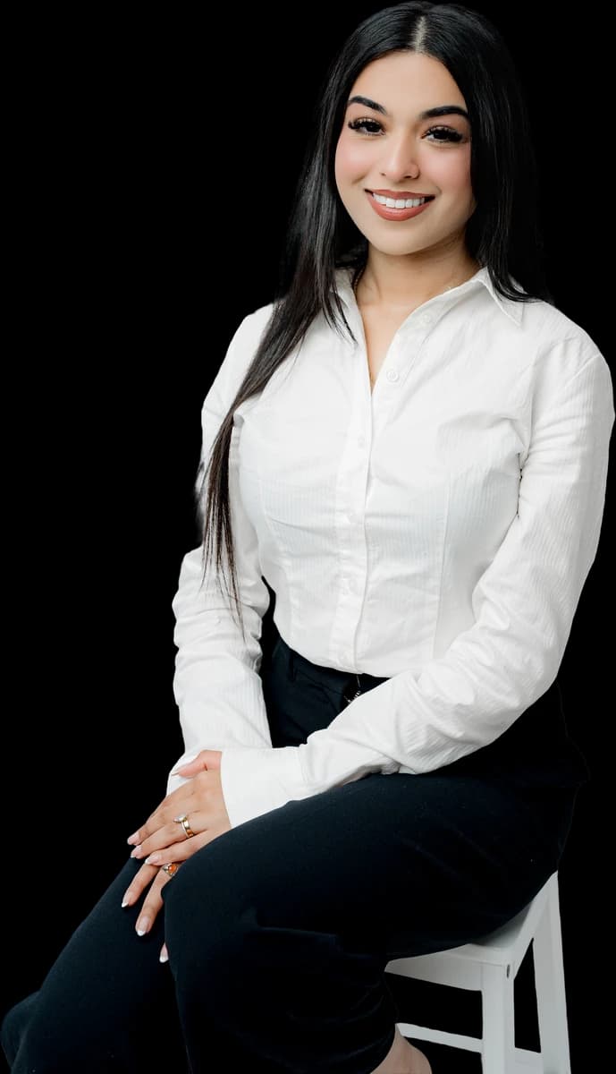 Alayna seated and smiling in a white blouse