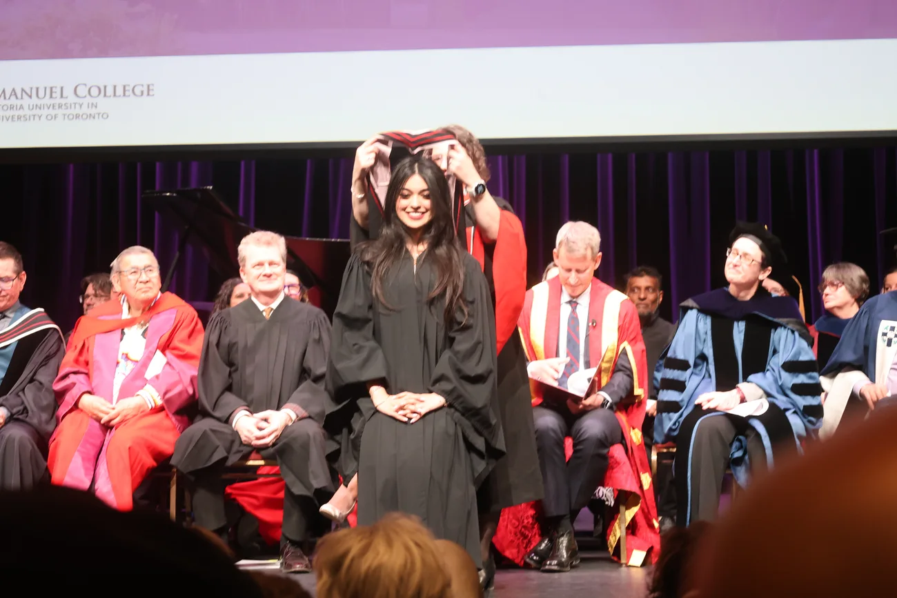 Alayna smiling on stage during her graduation ceremony at Emmanuel College